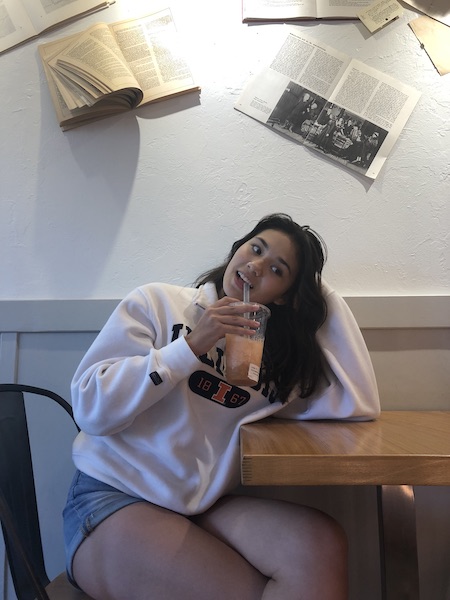 photo of girl at cafe table smiling with boba tea